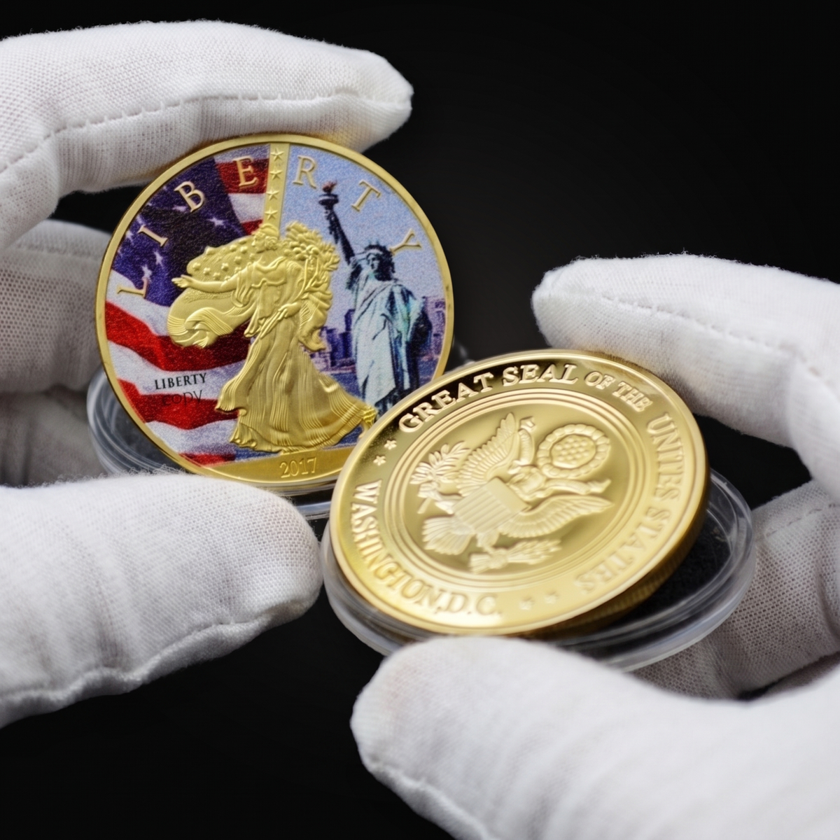 Liberty Coin Union Crest Edition held in white cotton conservator gloves, the colourised face toward the camera